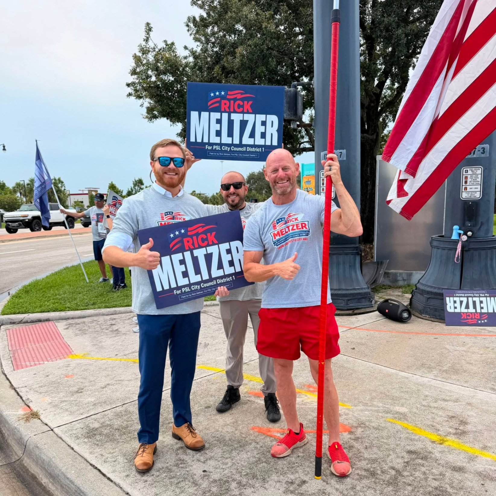 Rick Meltzer with supporters waving at a busy intersection