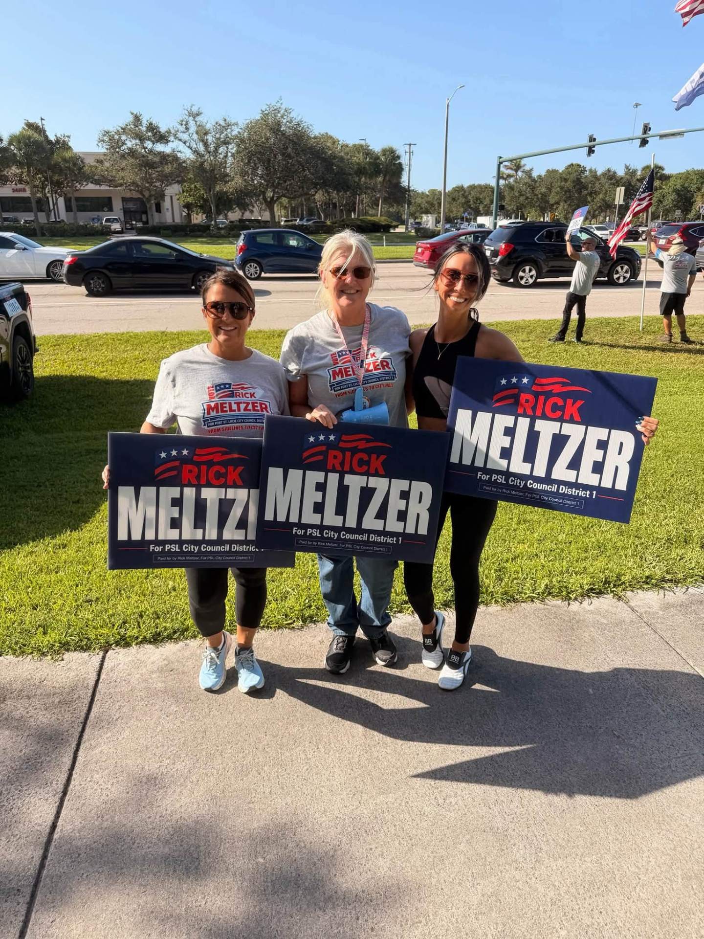 Three volunteers holding Meltzer campaign signs